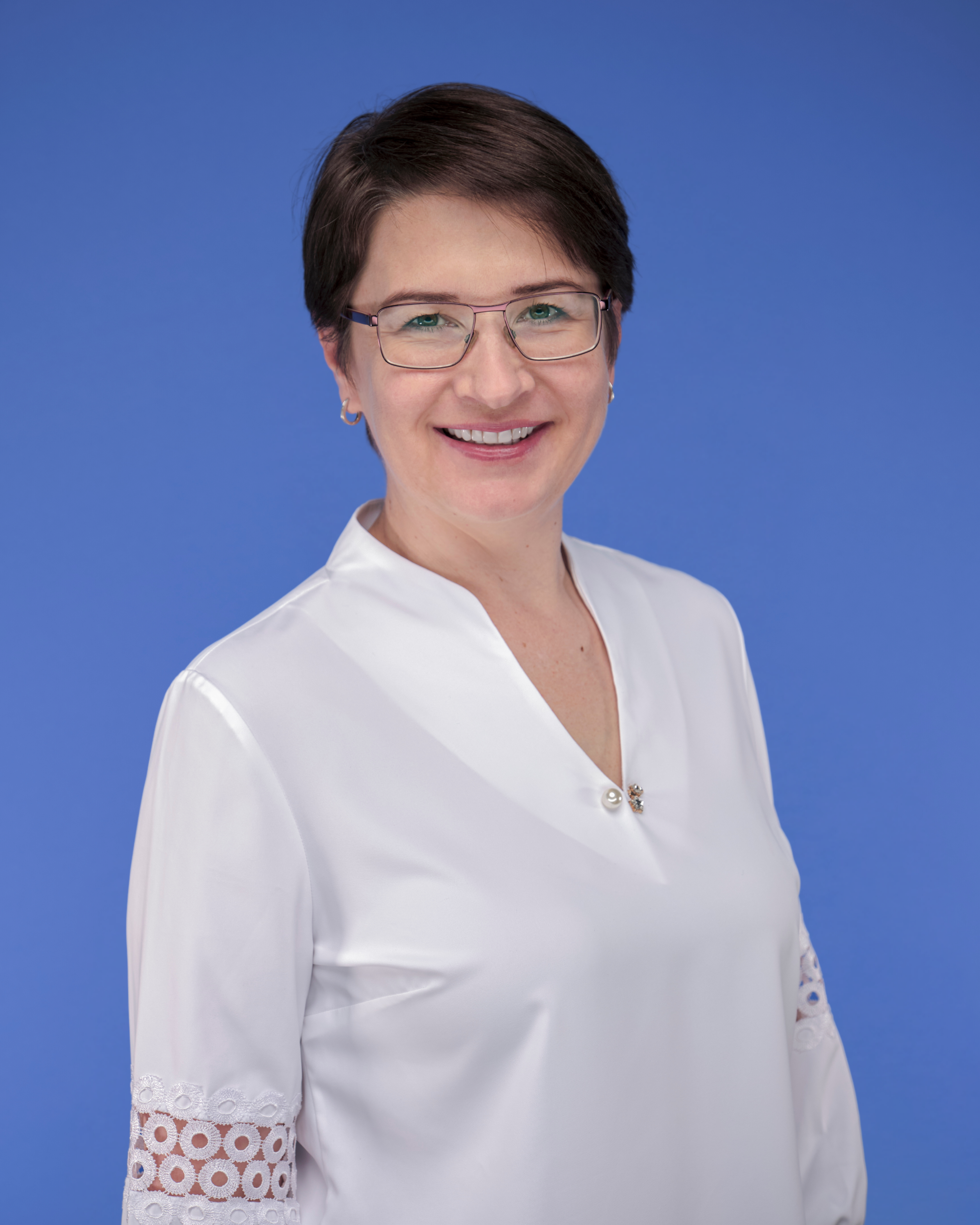 a person wearing glasses and a white blouse