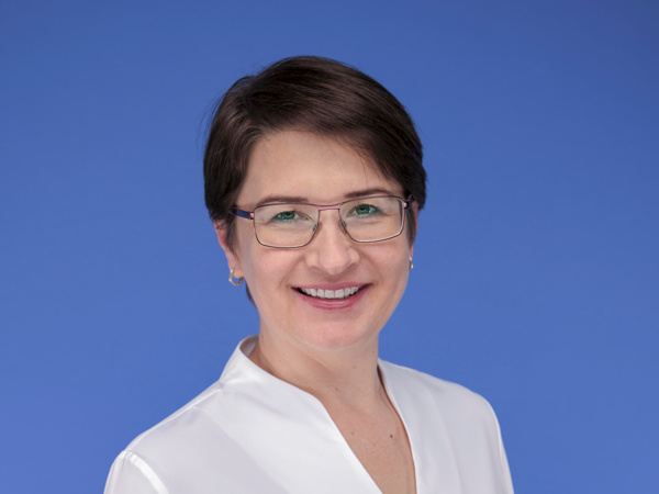 a person wearing glasses and a white blouse