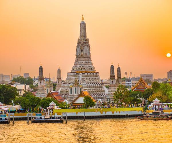 a large building with Wat Arun and a body of water