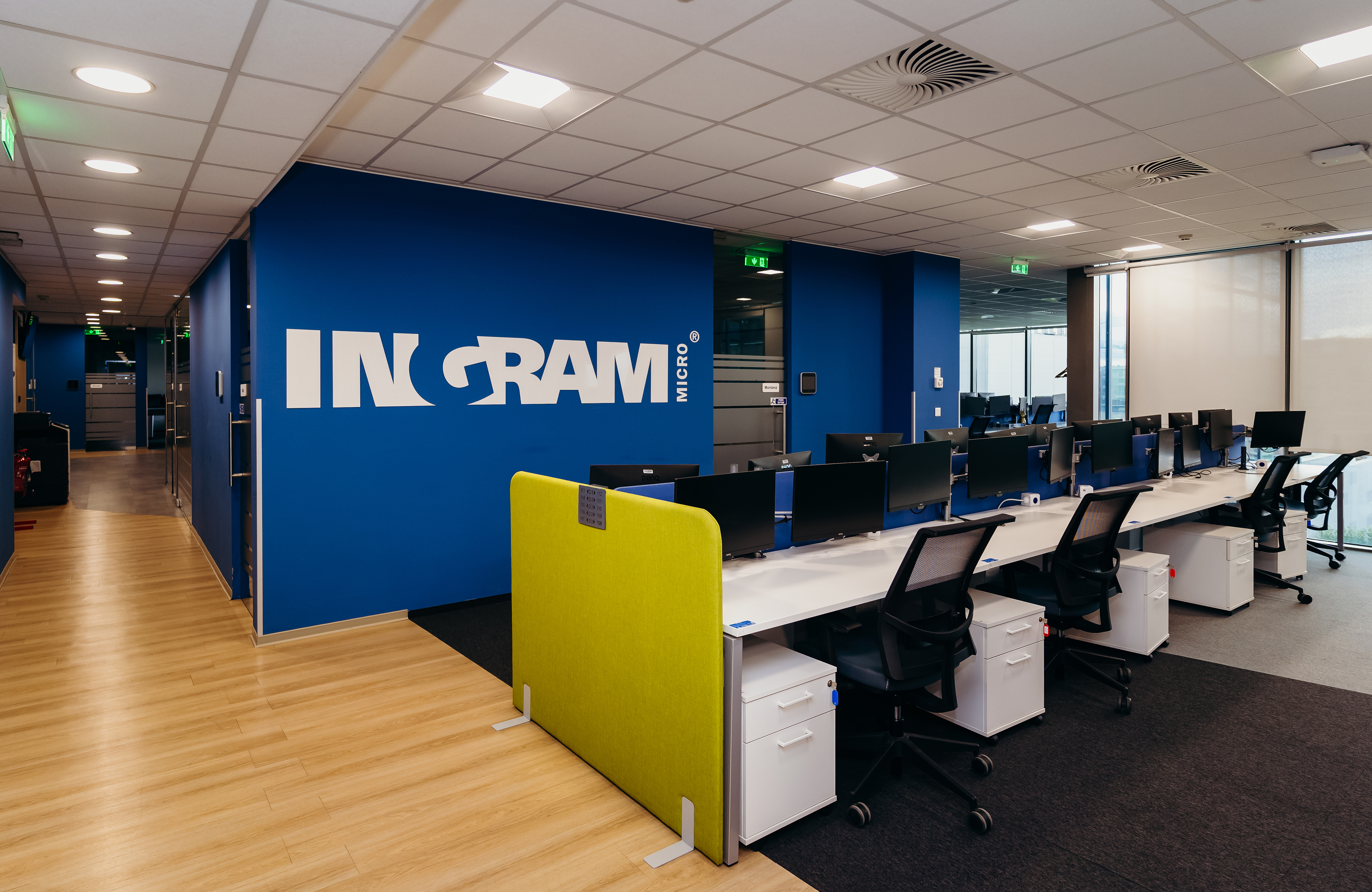 a room with a blue wall and white desks
