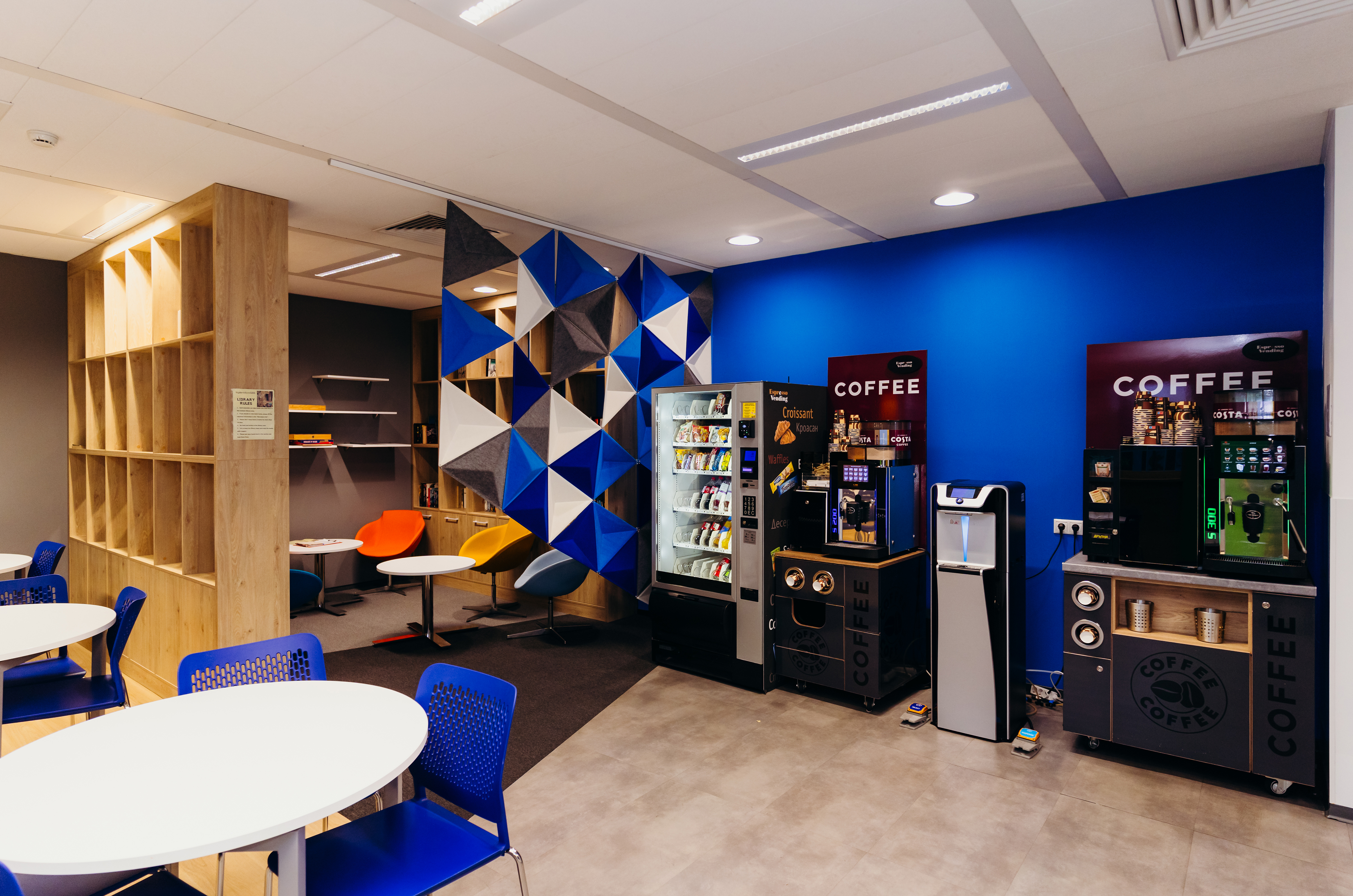 a room with a blue wall and a white table and chairs