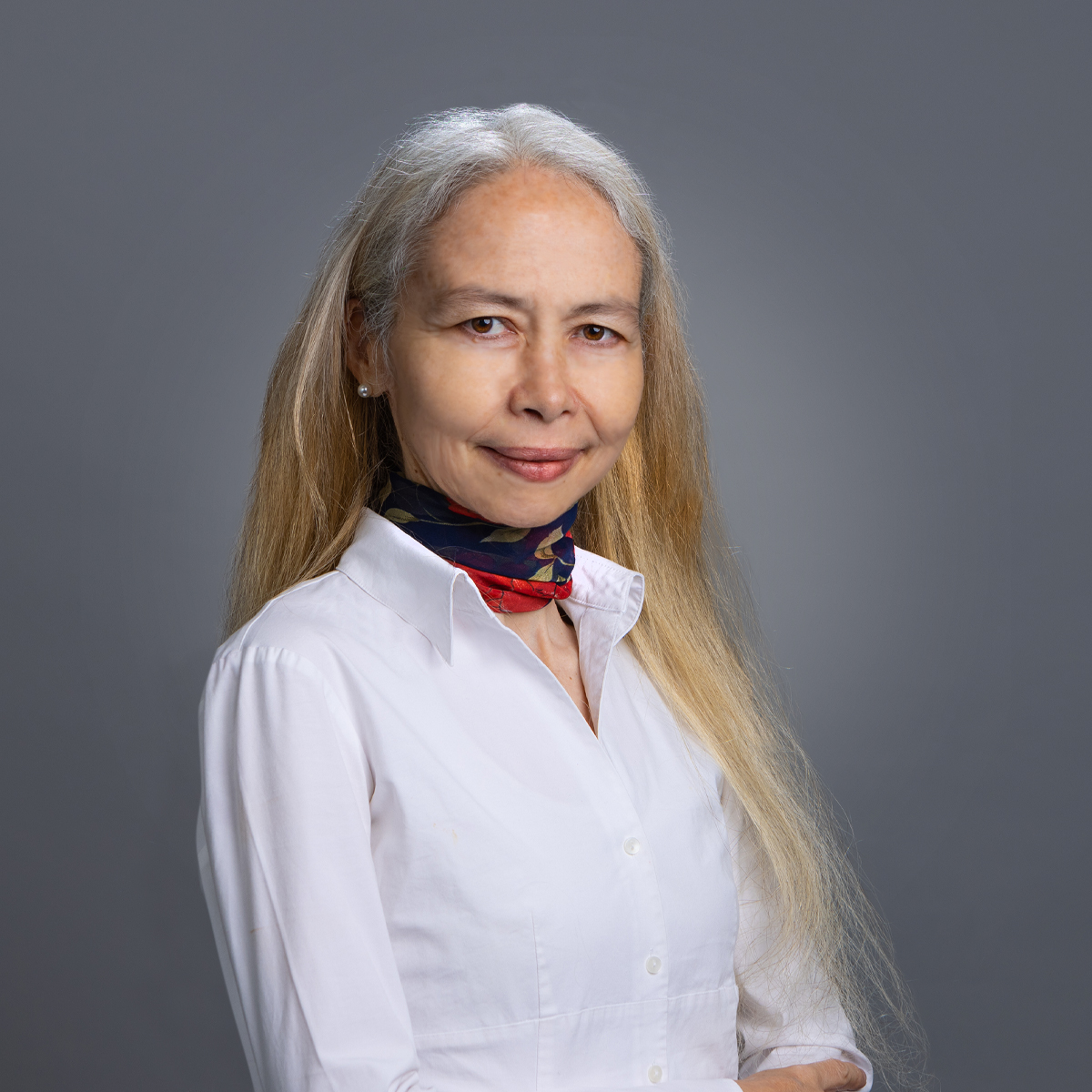 a person with long hair wearing a white shirt and scarf