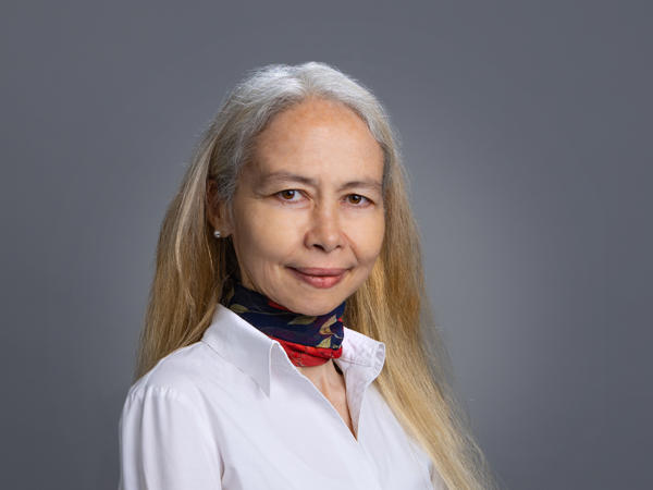 a person with long hair wearing a white shirt and scarf