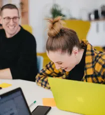 a person and person looking at laptops