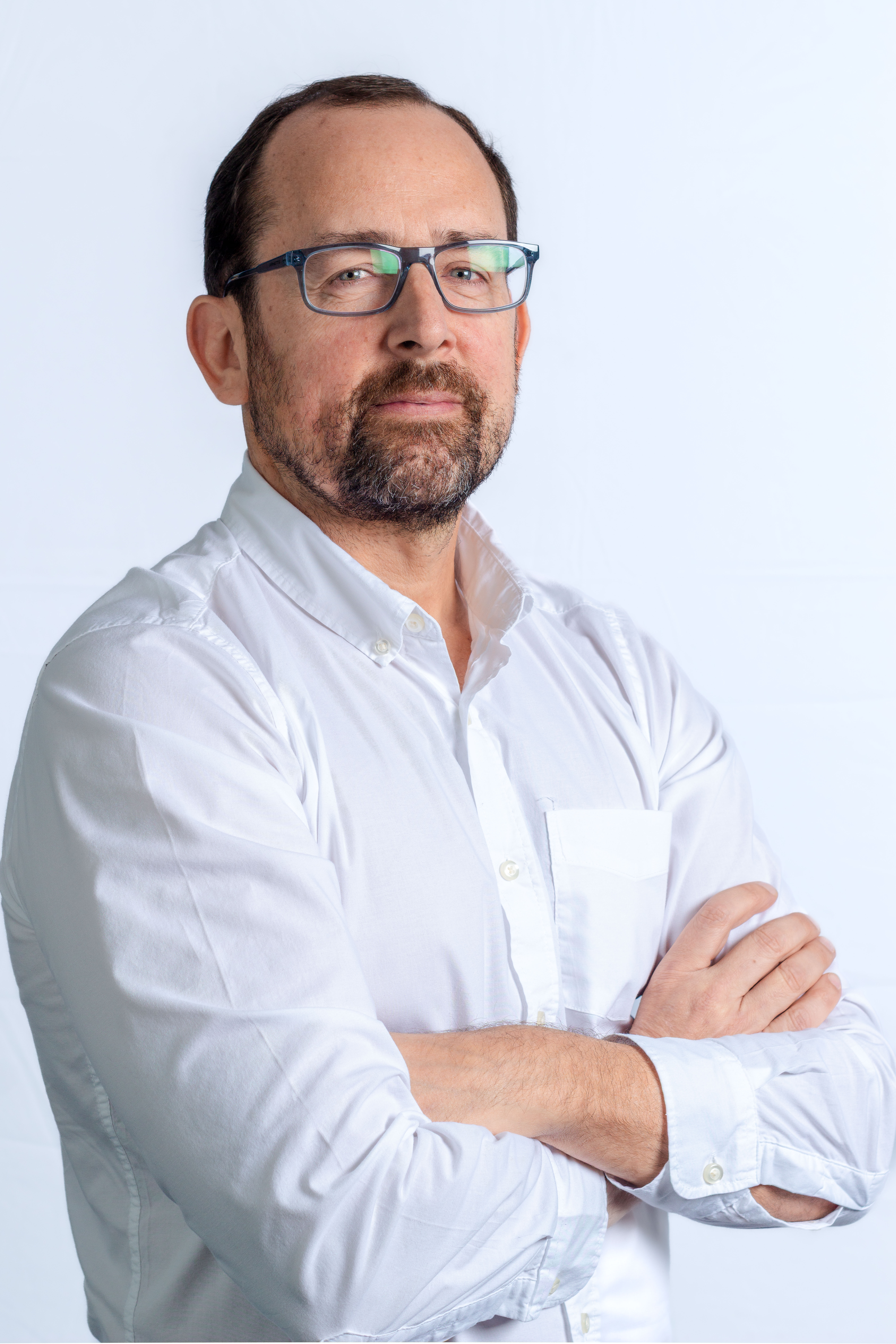 una persona con gafas y barba vestida con camisa blanca