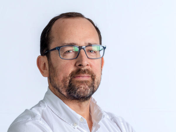 una persona con gafas y barba vestida con camisa blanca