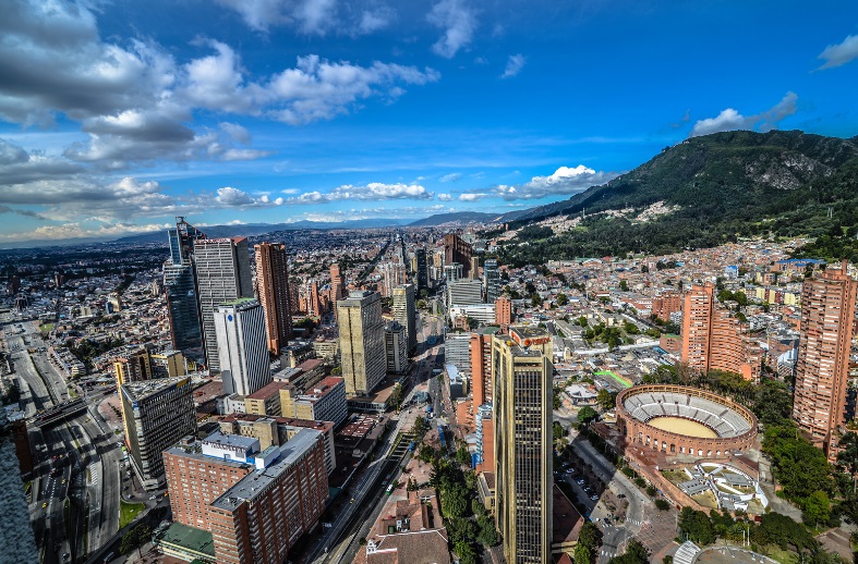 a city with a stadium and mountains in the background