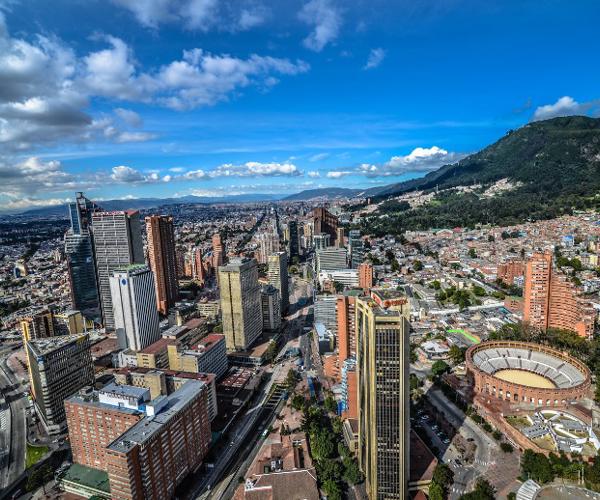 a city with a stadium and mountains in the background