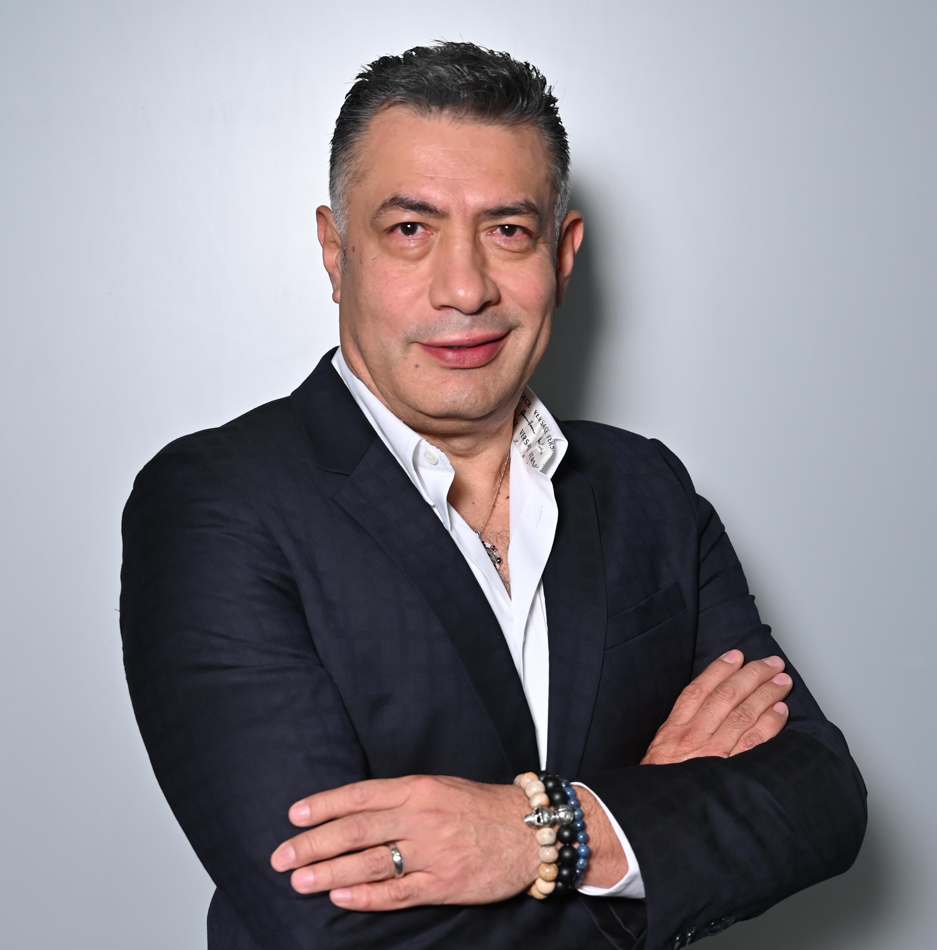 a person in a suit with his arms crossed