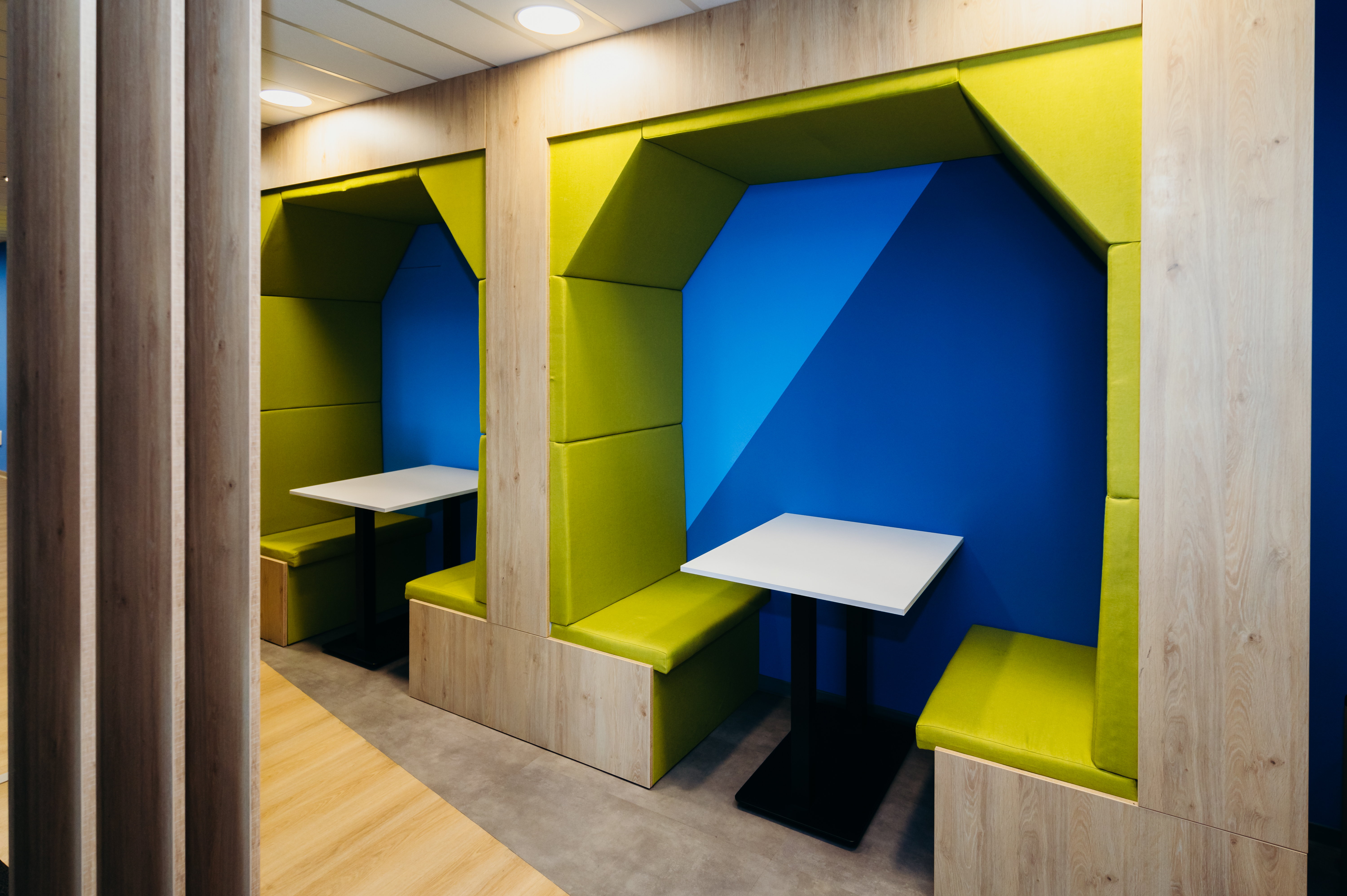 a room with green and blue seats and tables