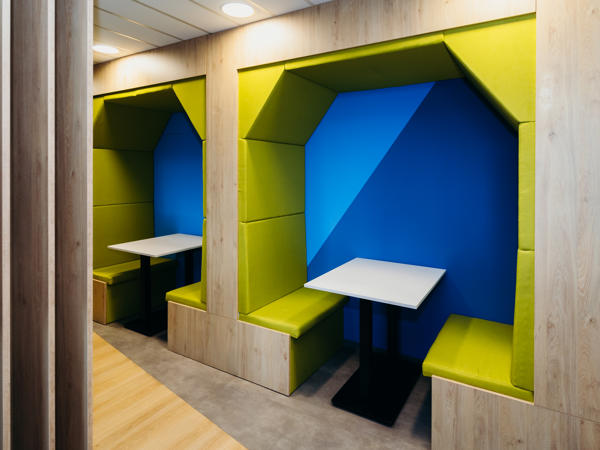 a room with green and blue seats and tables