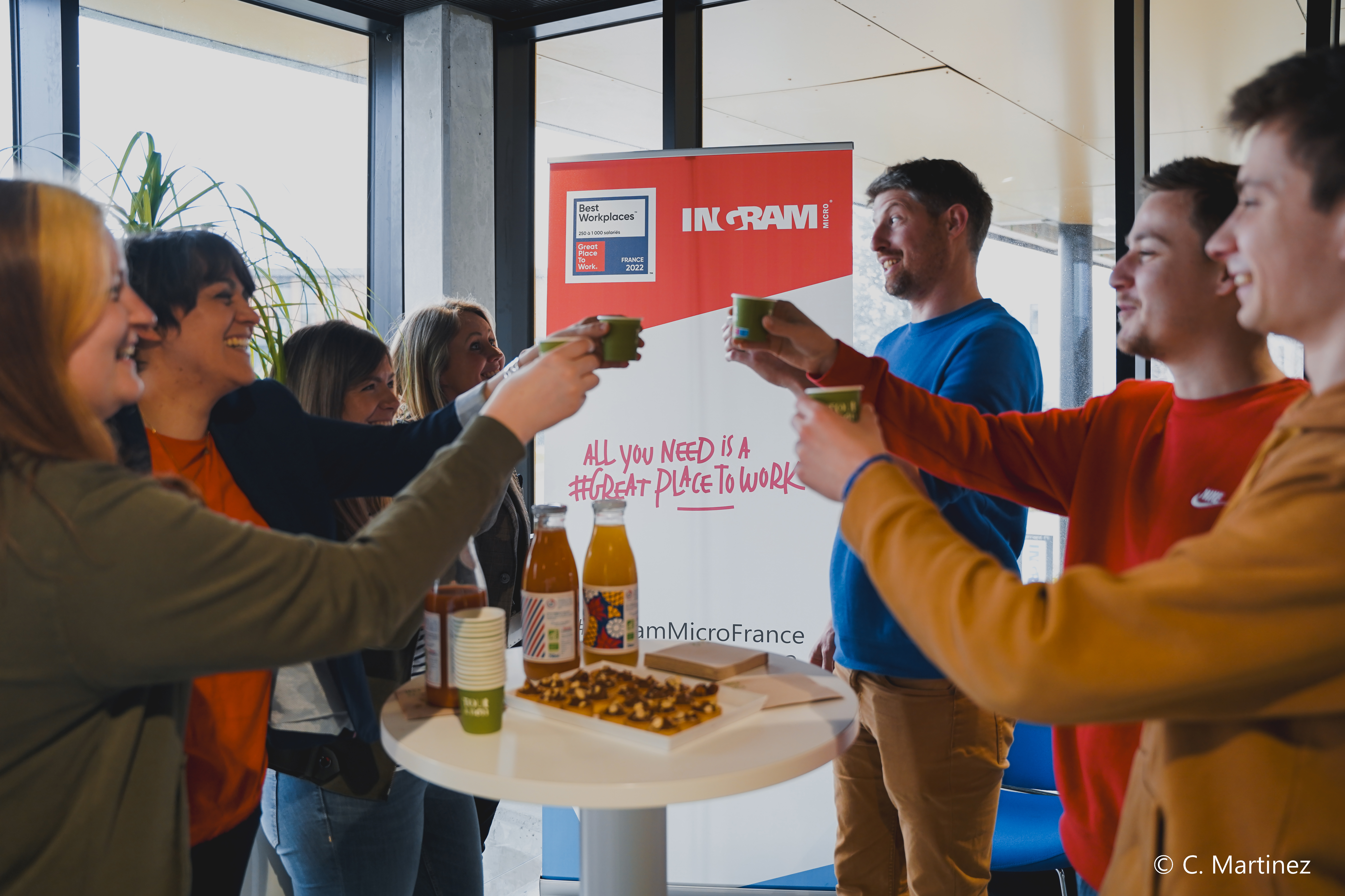 un groupe de personnes tenant des tasses et debout autour d’une table
