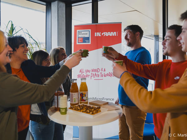 un groupe de personnes tenant des tasses et debout autour d’une table