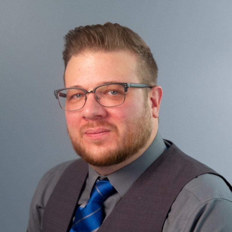 a person wearing glasses and a vest
