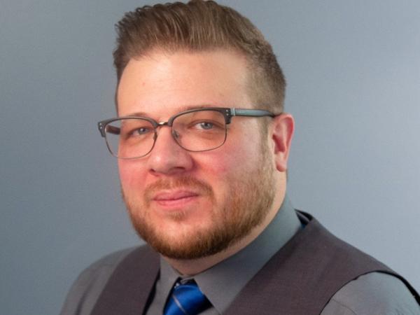 a person wearing glasses and a vest