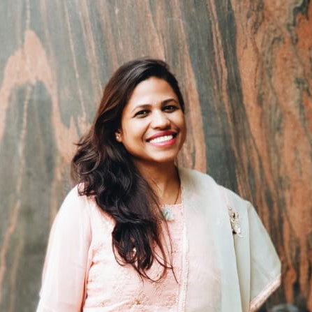 a person smiling in front of a wall