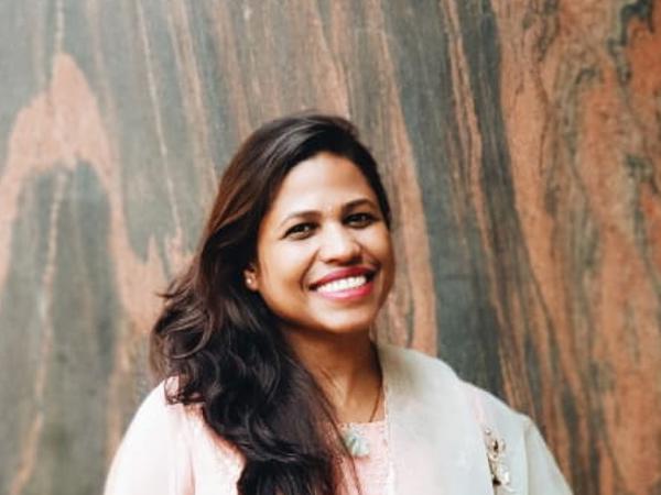 a person smiling in front of a wall