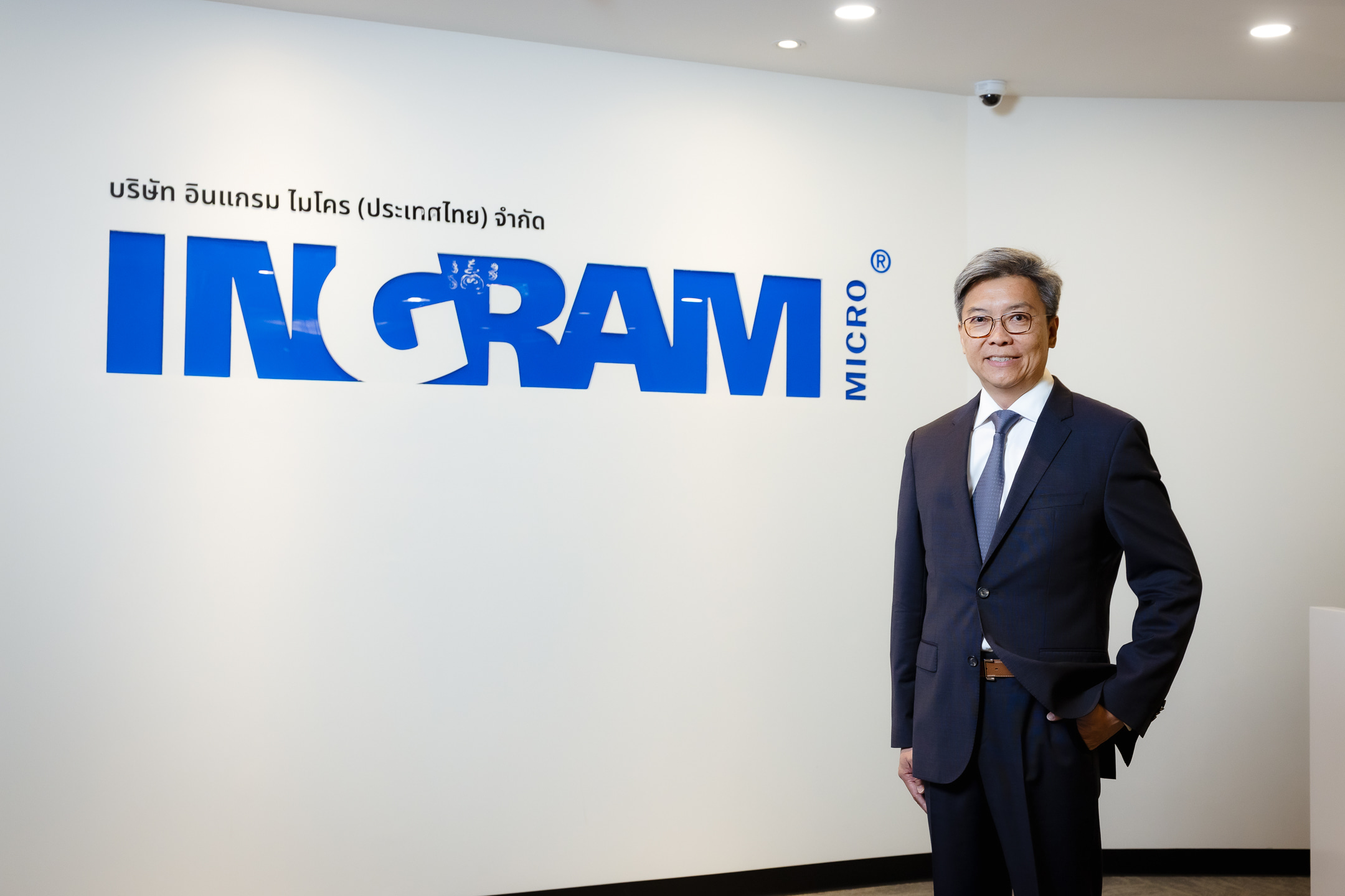 a person in a suit standing in front of a sign