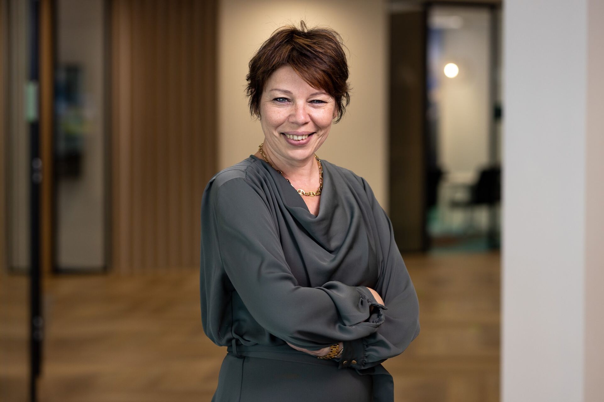 a person smiling with her arms crossed
