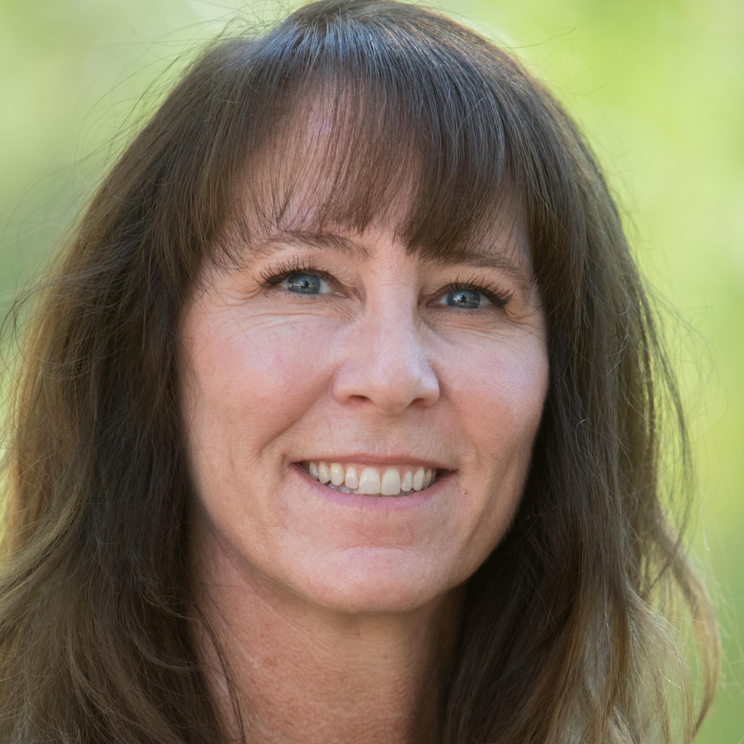a person with long brown hair smiling
