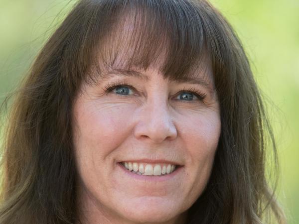 a person with long brown hair smiling