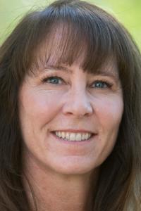 a person with long brown hair smiling