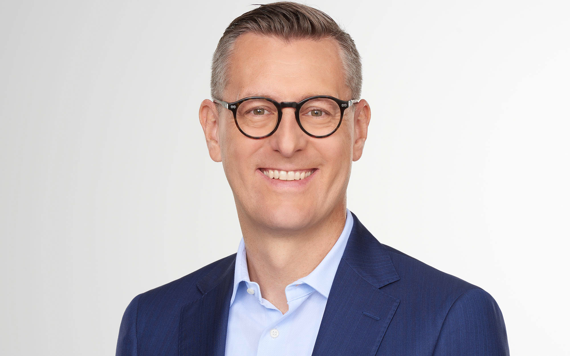 a person wearing glasses and a blue suit