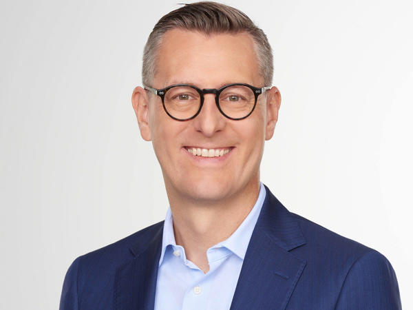 a person wearing glasses and a blue suit