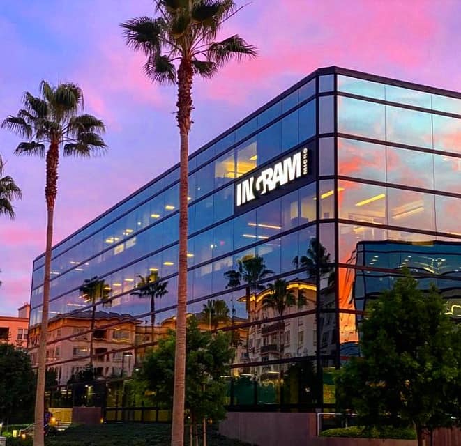a building with palm trees and a pink sky