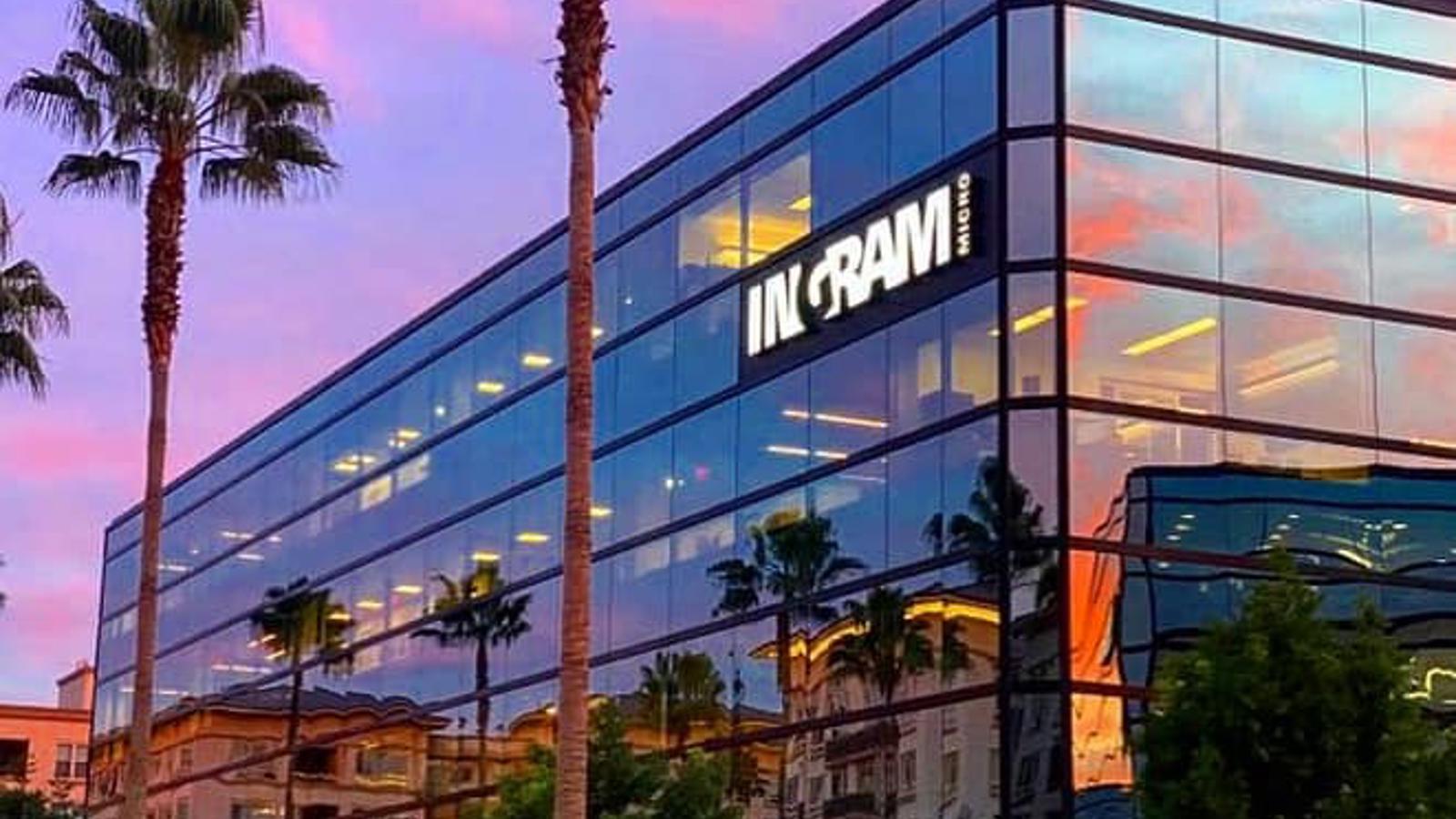 a building with palm trees and a pink sky