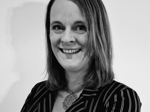 a person smiling with arms crossed