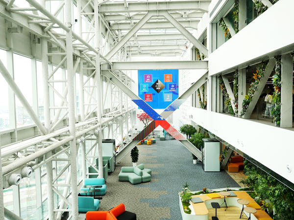 a large building with white beams and blue chairs