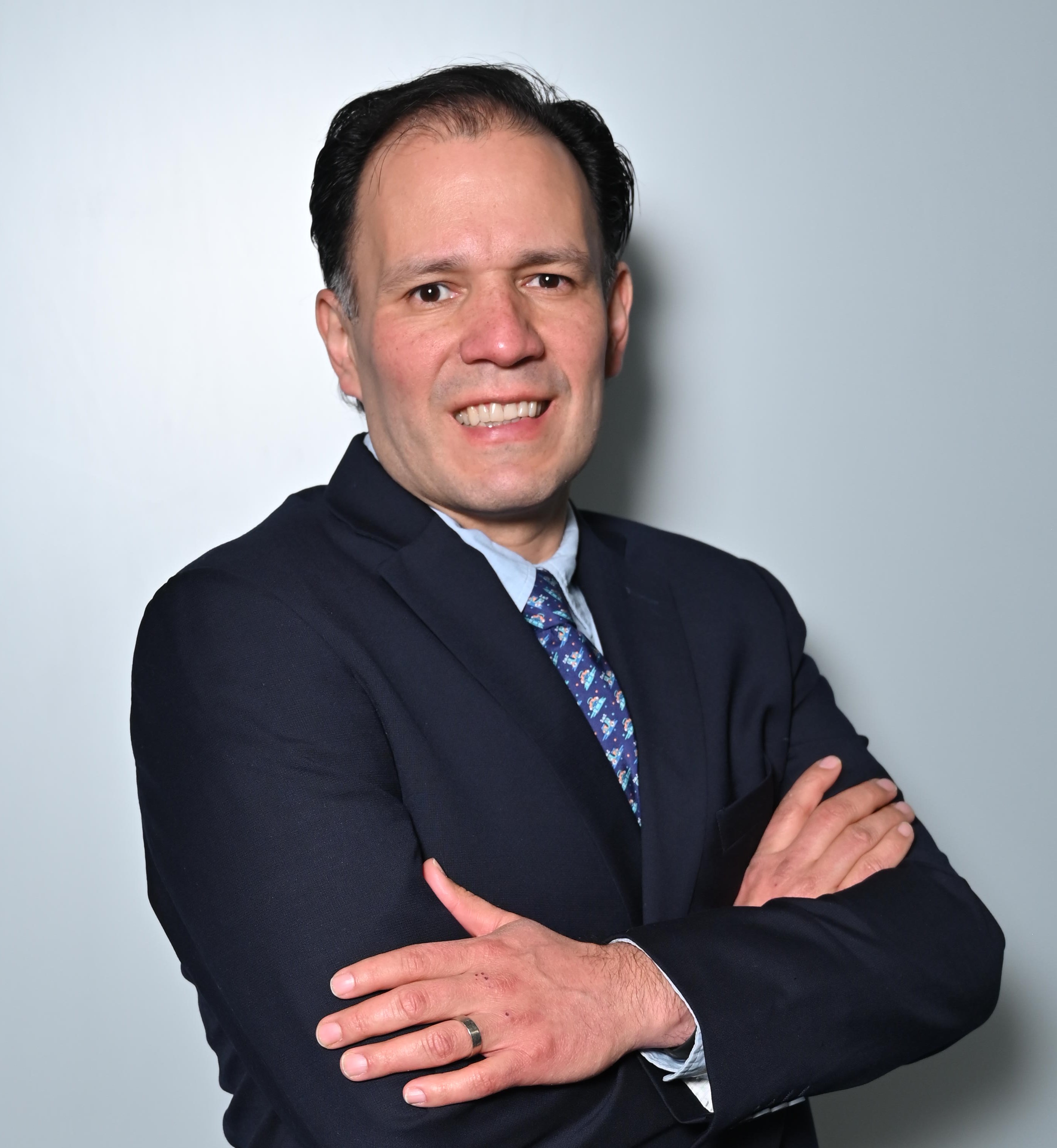 a person in a suit with his arms crossed