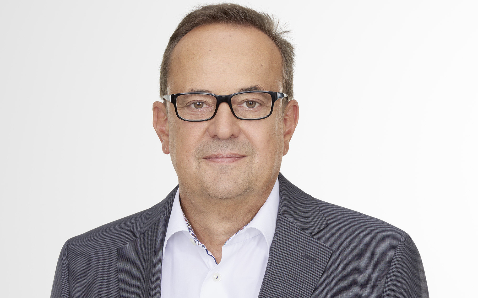 a person wearing glasses and a suit