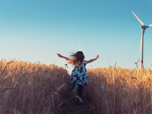 a child running through a field of wheat