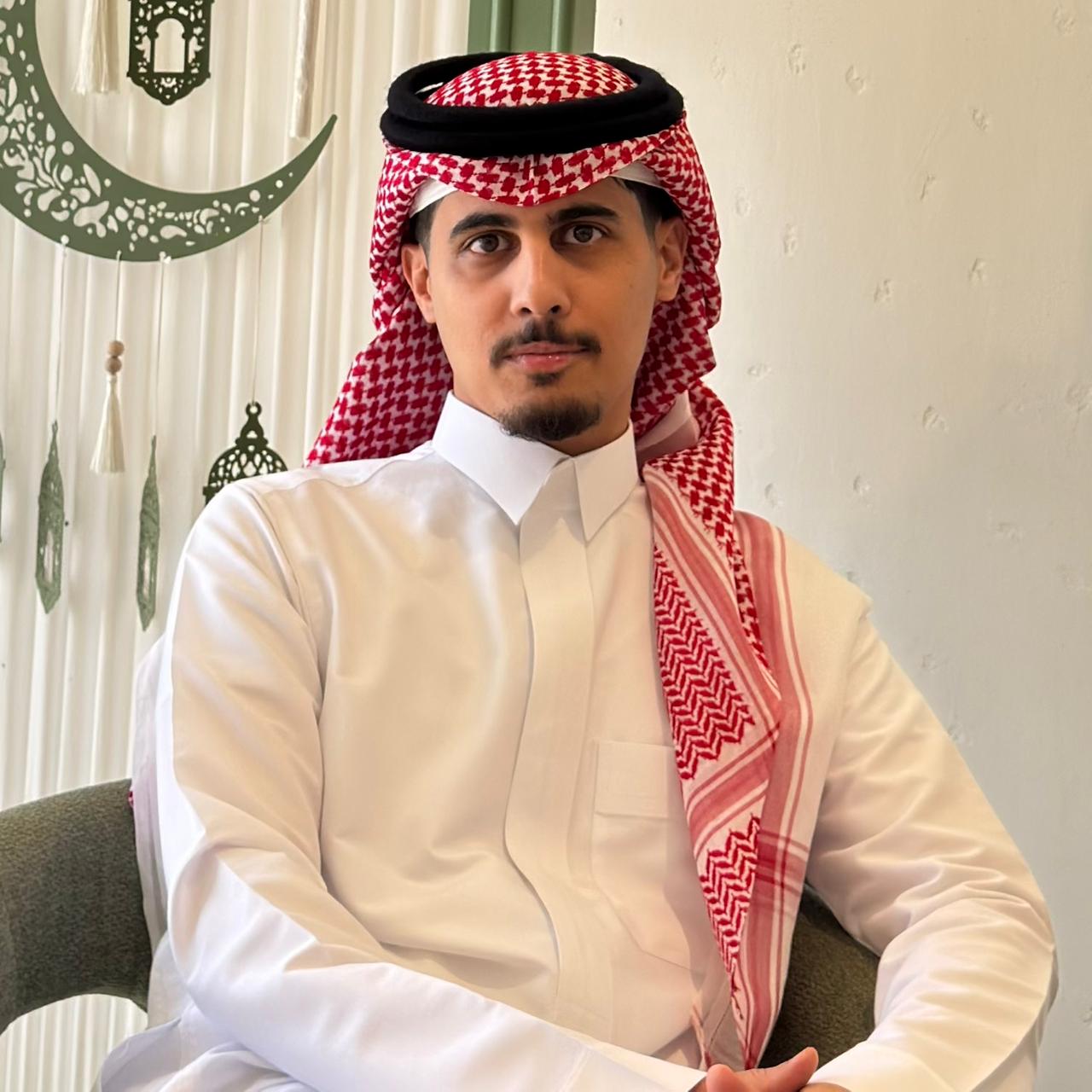 a person in a white shirt and red headdress