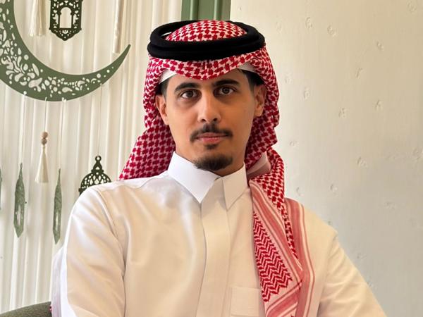 a person in a white shirt and red headdress