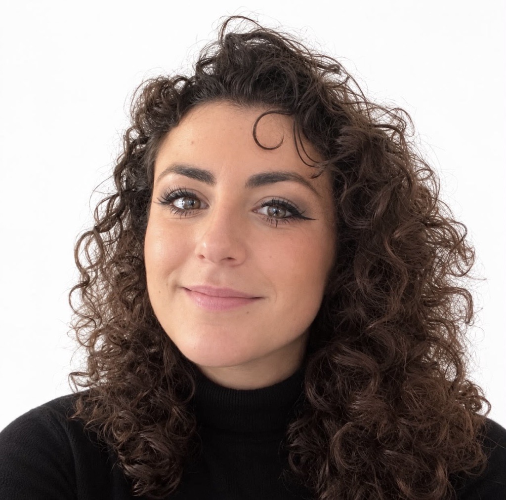 a person with curly hair smiling
