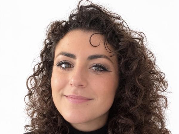 a person with curly hair smiling