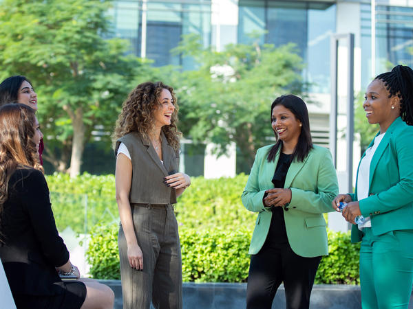 Five Female Associates Speaking Outside The Office