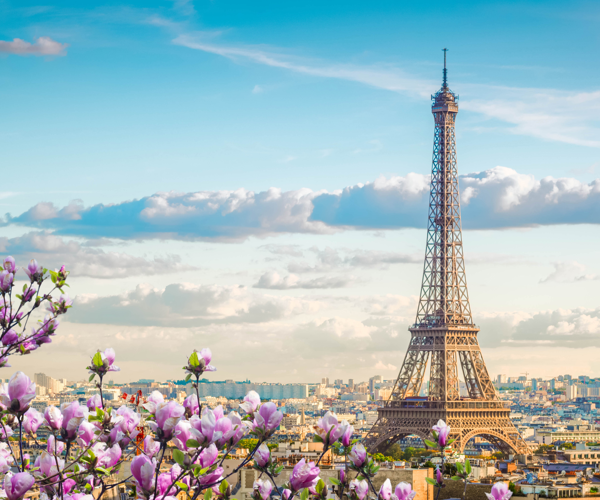 a tall metal tower with a city in the background