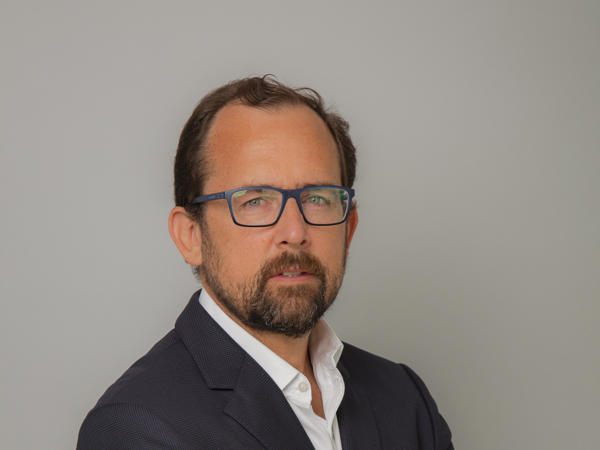 una persona con gafas y barba vestida con un traje