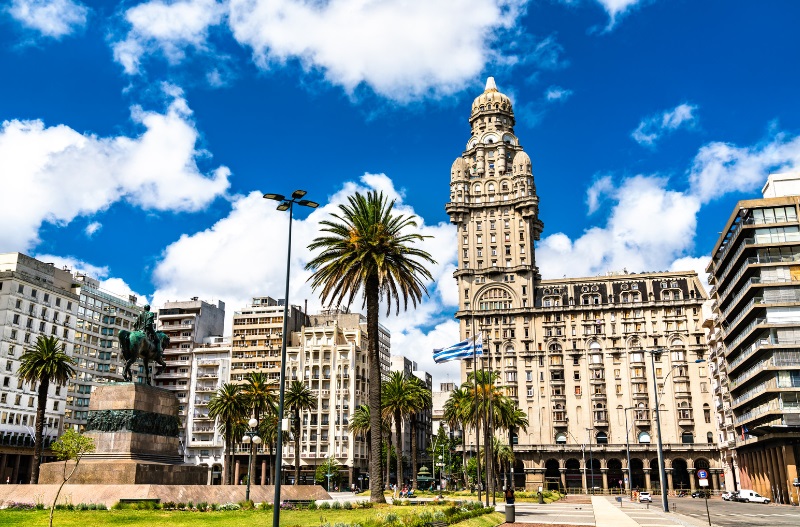 a tall building with a clock tower and palm trees