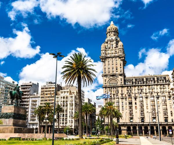 a tall building with a clock tower and palm trees