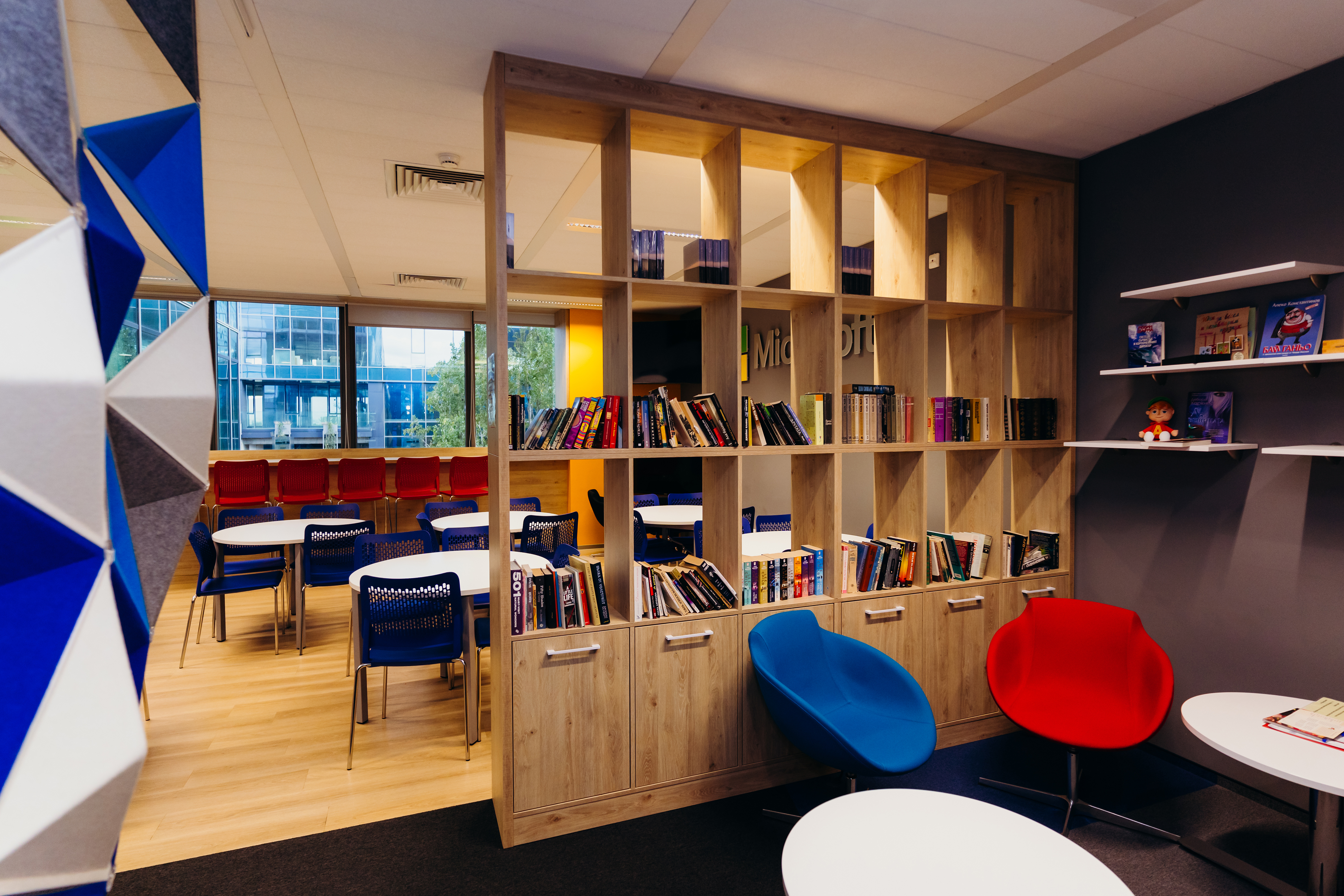 a room with a book shelf and chairs