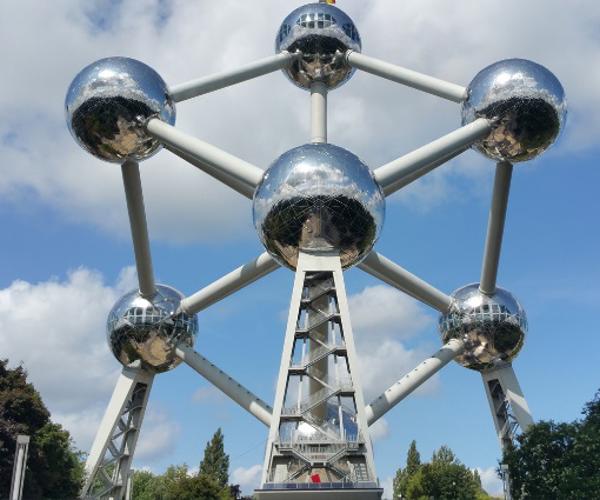 a large structure with persony spheres with Atomium in the background
