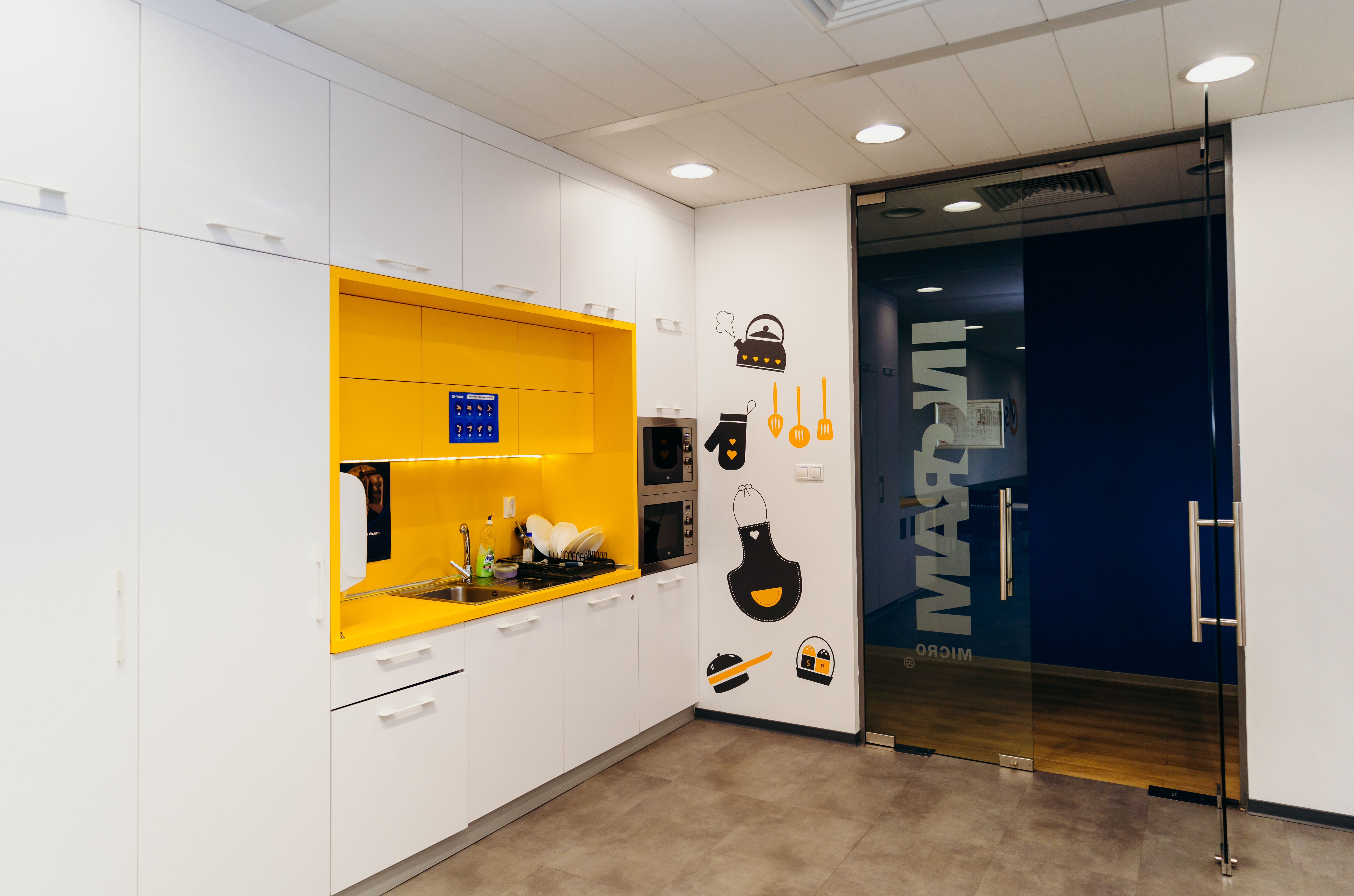 a white and yellow kitchen with a glass door