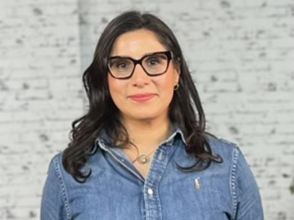 a person wearing glasses and a denim shirt