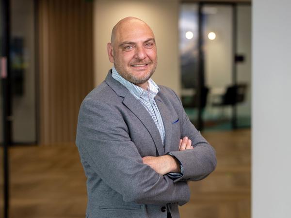 a person in a suit with his arms crossed