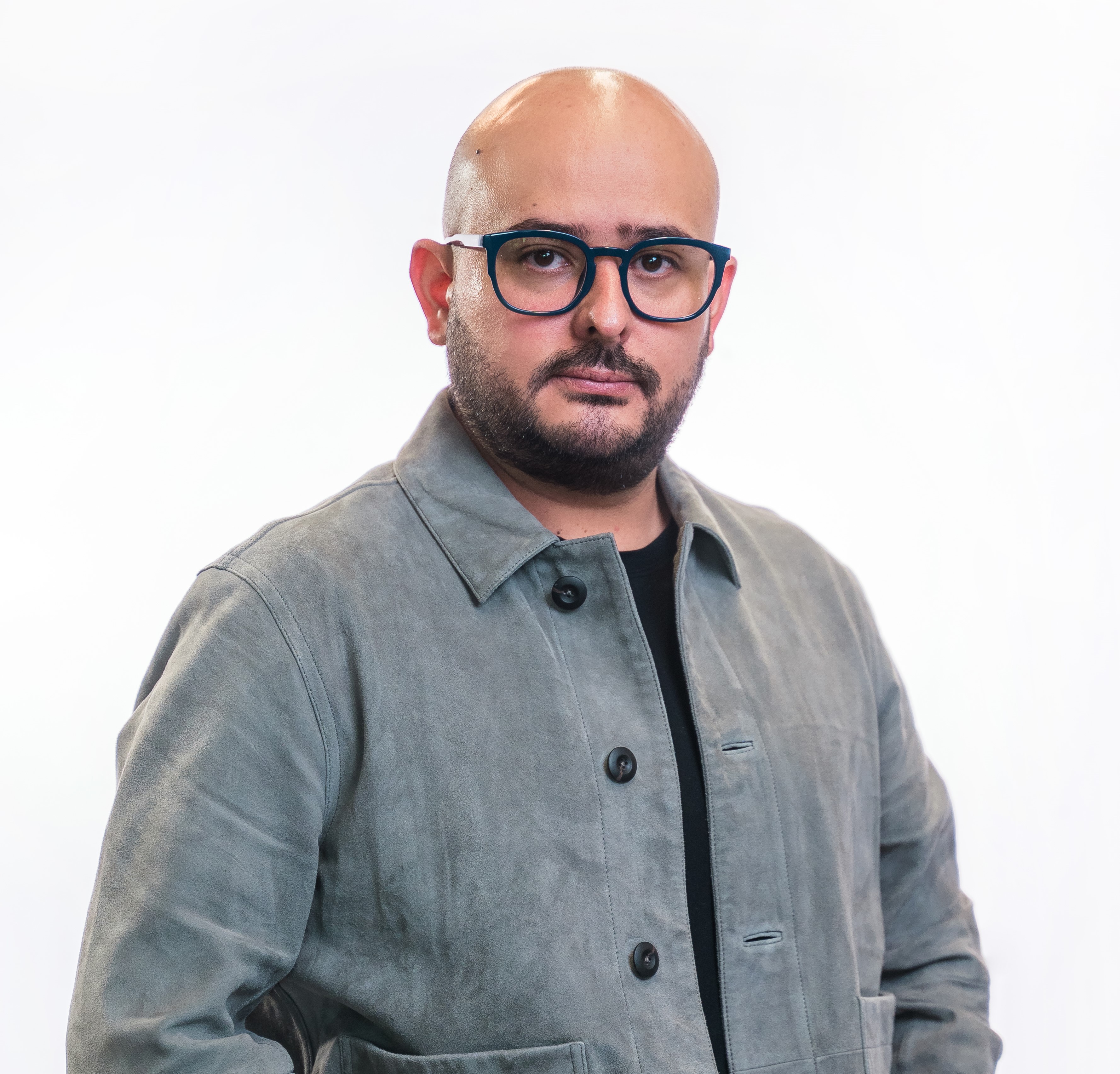 a person wearing glasses and a grey jacket